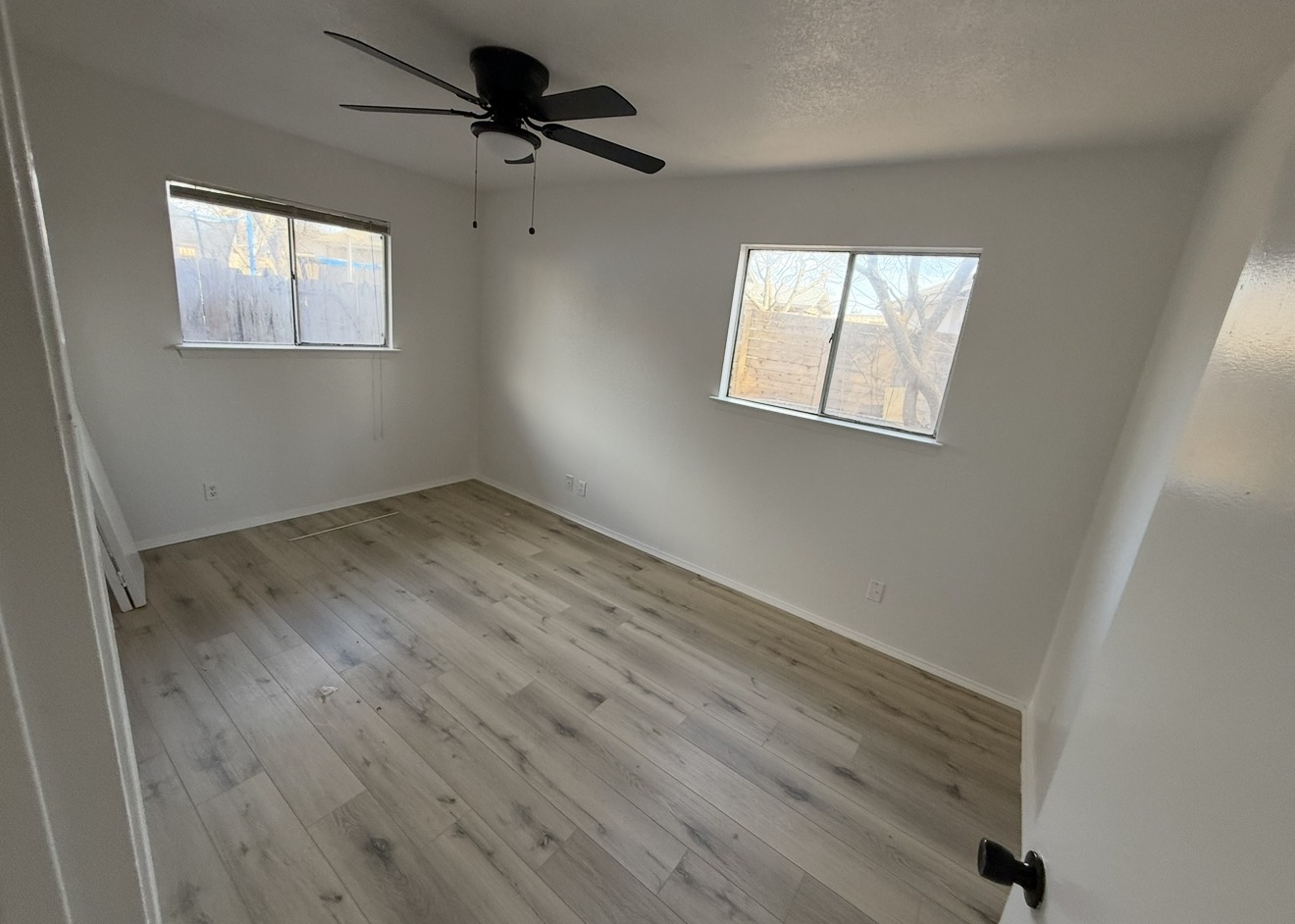 Renovated room with light wood-look flooring and white walls