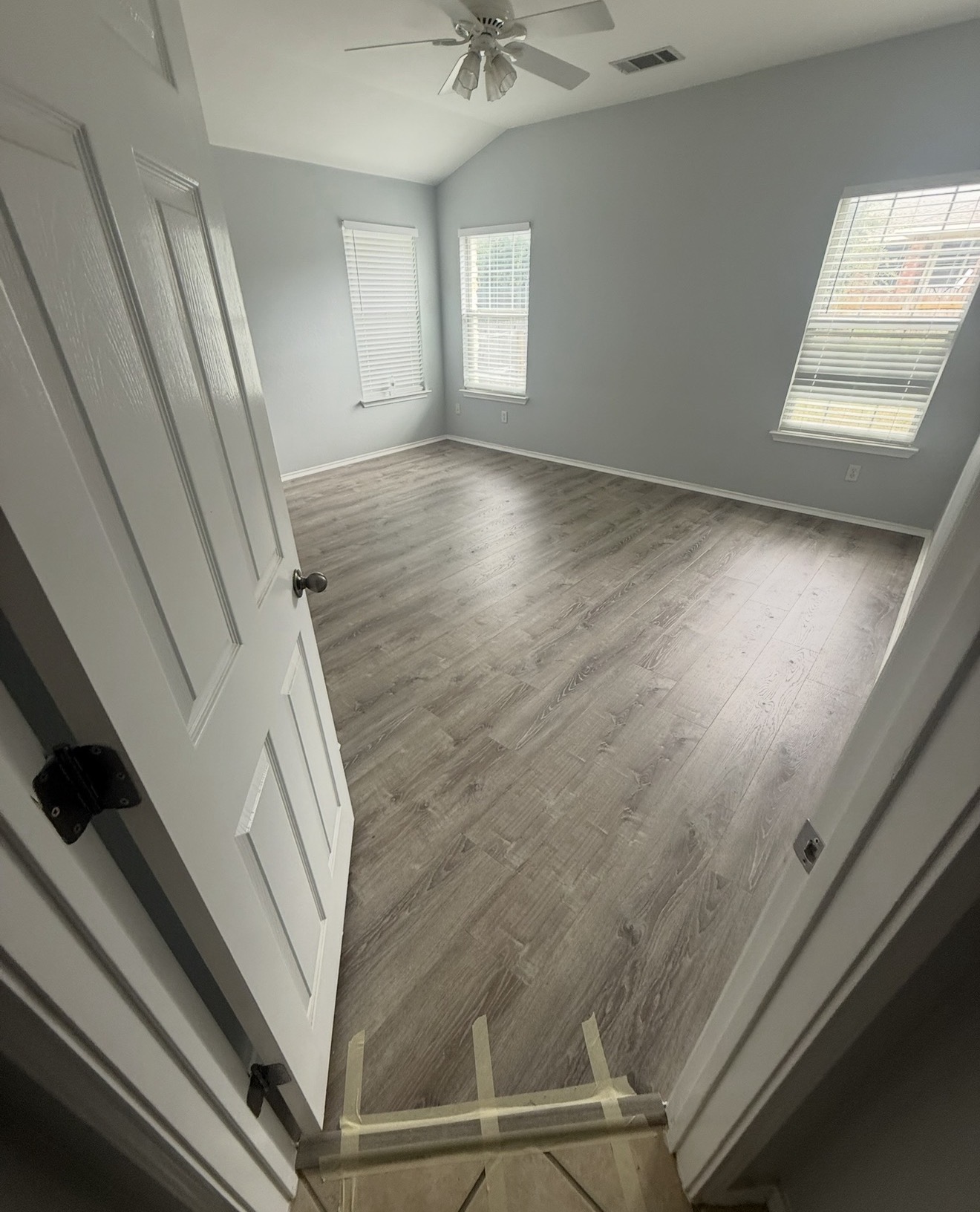 New gray luxury vinyl plank flooring in a bright bedroom