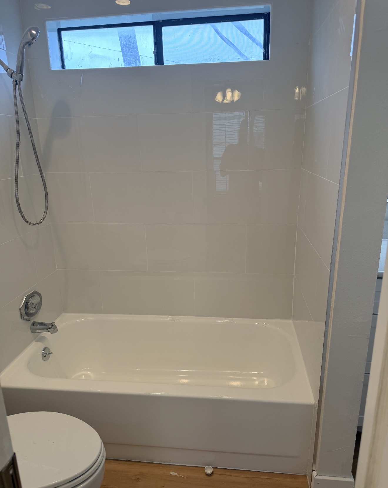 Completed white tile bathtub surround in an Austin-area bathroom
