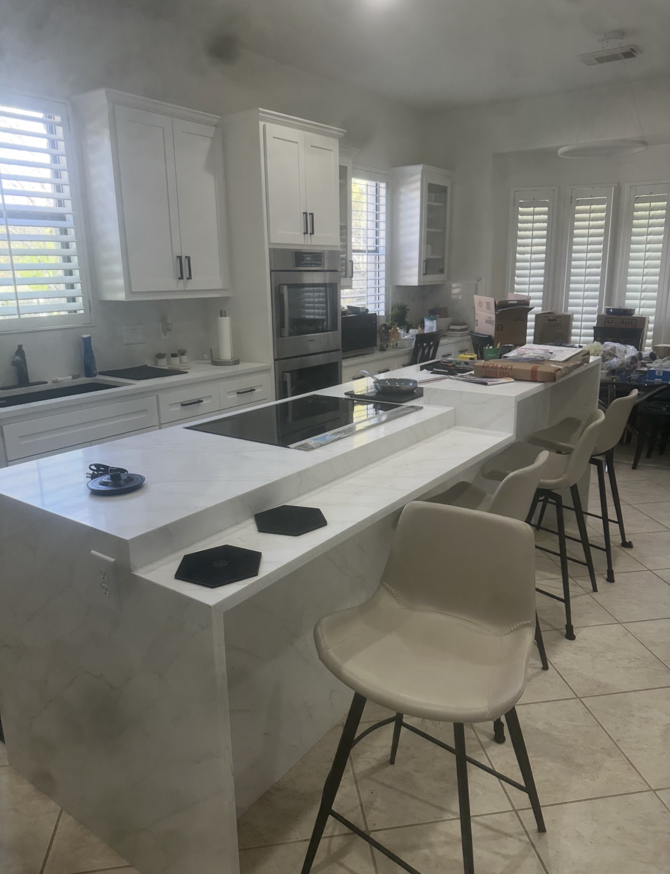Completed kitchen remodel with white shaker cabinets, quartz countertops, and a two-tier island